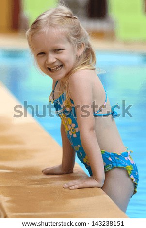 little girl  near the open-air swimming pool