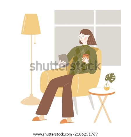 Woman sits in comfy chair, using tablet. Cozy room interior with floor lamp, big window, cooffee table