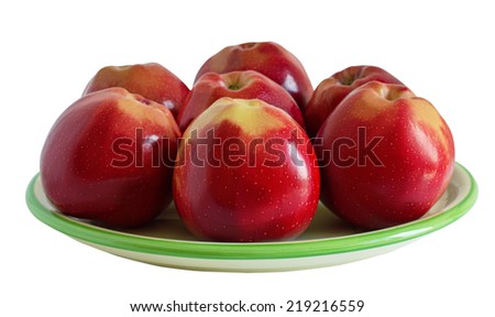 Seven red apples on the green plate isolated on white background