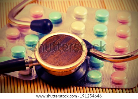 Old stethoscope on background tabs. Vintage style