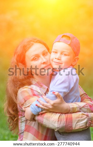 Mother and son hugging in the street and look right. Family composition
