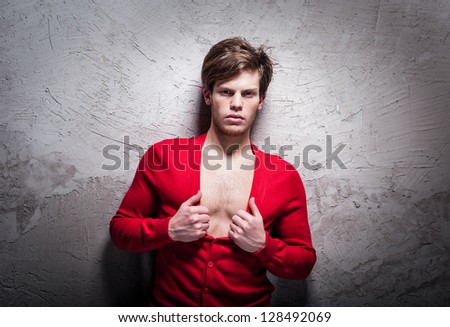 Young man posing in red cardigan