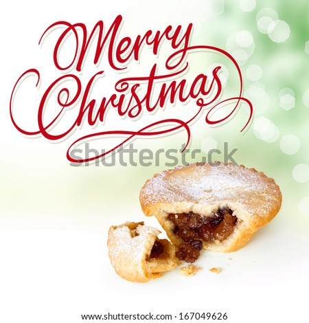 Christmas Holidays Greeting Card. Merry Christmas calligraphic type lettering with Mince Pie Broken Open on Christmas Tree background with bokeh lights