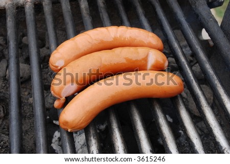 Cooking sausages on outdoor barbecue
