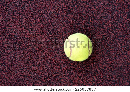 A yellow tennis ball on the ground