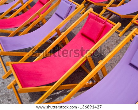 Classic wooden beach chairs in purple and pink