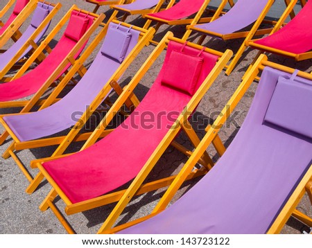 Classic wooden beach chairs in purple and pink