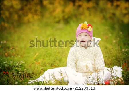 funny beautiful girl with Down syndrome in the autumn park
