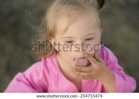 Girl with Down syndrome pulls his fingers in his mouth