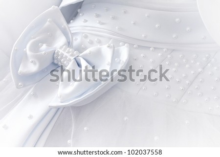 Close up of large bow on white bridal dress decorated with pearls
