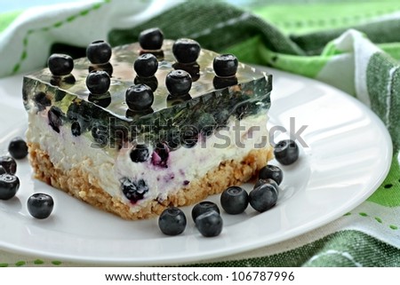 Piece of home made cheesecake with blueberries and green jelly