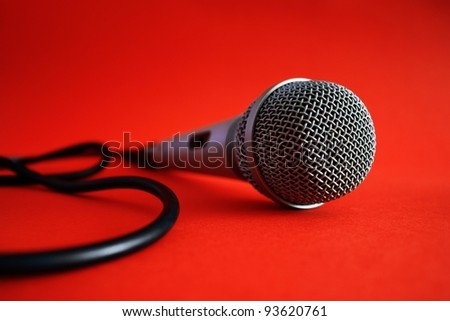 Close up of professional metal silver microphone on red background