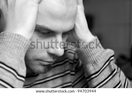 Caucasian man sitting with head in hands looking depressed