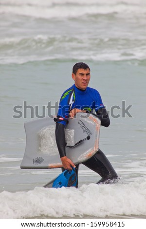 SAN FERNANDO, CADIZ, SPAIN - FEB 19: Unidentified bodyboader leaving the water on the 2nd championship of Surf and BodyBoard Impoxibol on Feb 19,2011 on the beach of San Fernando, Cadiz, Spain
