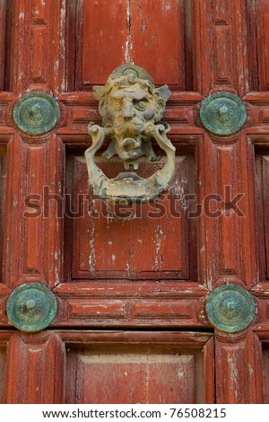 Detail of an ornate door knocker on the door of a building