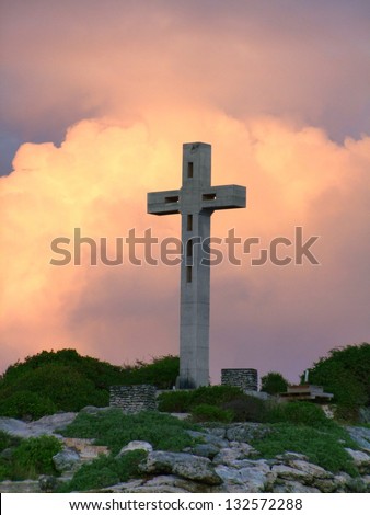 colorful sundown scenery on a caribbean island named Guadeloupe including a summit cross on mountain top