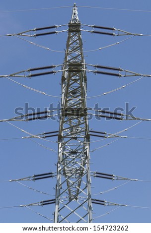 detail of a overhead power line in front of blue sky