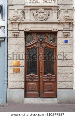 historic ornamented entrance with wooden entry door seen in Colmar, France