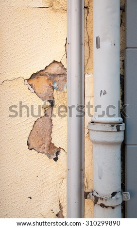 detail shot of a rundown house facade with downspout