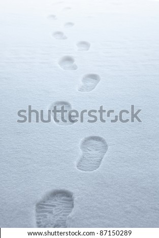 symbolic picture showing boot traces walking away in fresh fallen snow