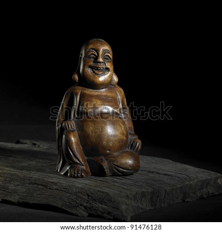 brown Buddha sculpture in dark back