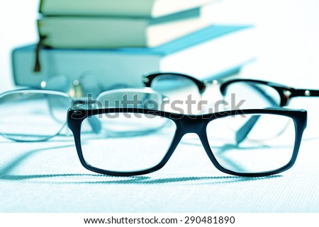 reading glasses and books on the white table