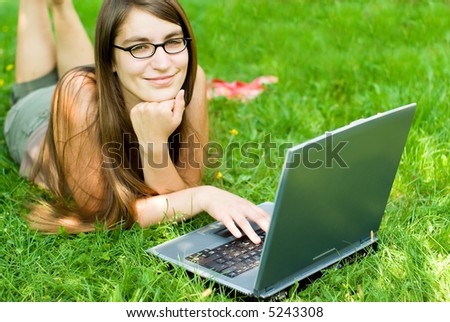 portrait of young woman surfing the internet outdoors on her notebook