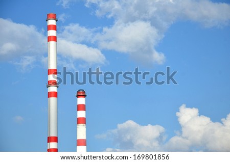 Two factory chimneys with sky in the background