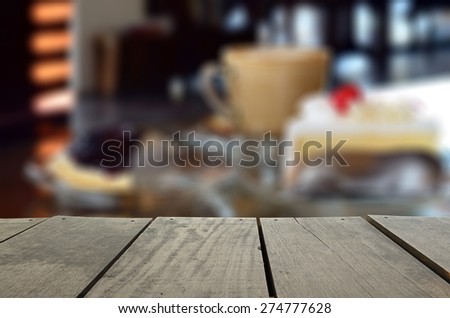 Defocused and blur image of cappuccino coffee and cake on desk for background usage