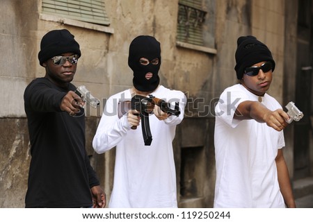 Gang members or guerrilla with gun and rifle on the street