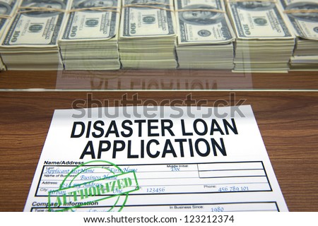 Approved disaster loan application form and dollar bills at cashier's desk