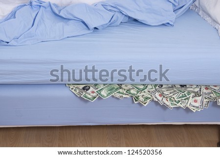 Savings or bank run concept: Hiding US dollars under the mattress