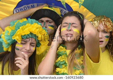 Group of sad crying brazilian soccer fans disappointed with team defeat.