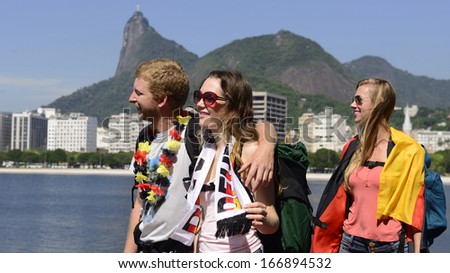 Group of German friends traveling at Rio de Janeiro holding Argentinian flag, with Christ Redeemer in the background.