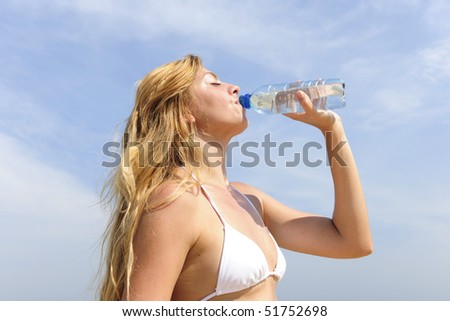 thirsty woman drinking water outdoors on a summer day
