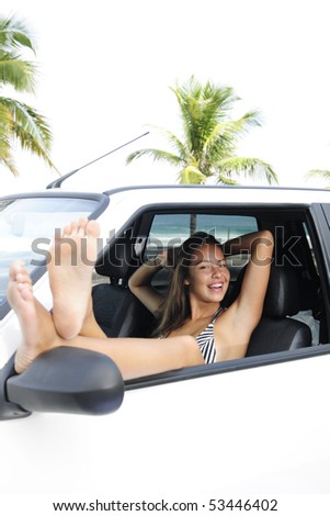 car rental: woman relaxing in her car near the beach