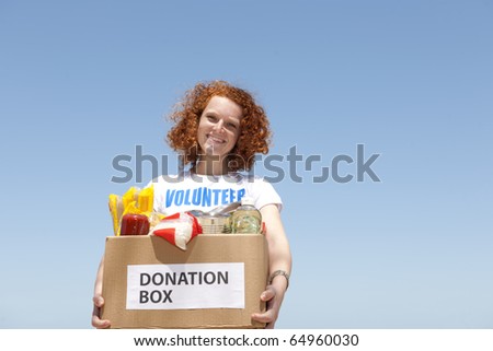 happy volunteer carrying food donation box