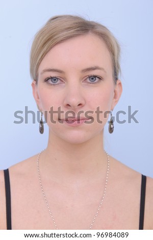 passport portrait of a young woman on blue background - Stock Image -  Everypixel