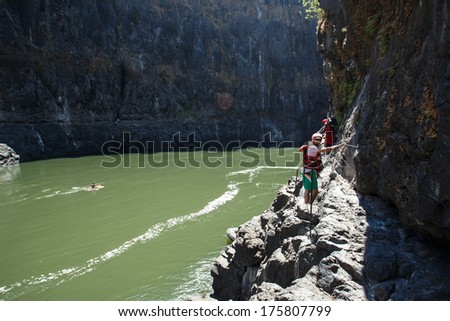 LIVINGSTONE - OCTOBER 01 2013: Tourism brings in huge revenue for Zambia. A canyoner scales the rock formation in the Zambezi river in Livingstone, Zambia, Africa