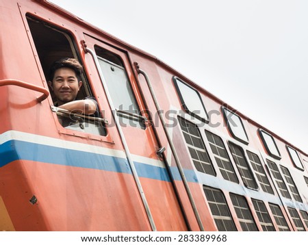 MAE TAN NOI, THAILAND - MARCH 22 2015: Train Driver at remote train station Mae Tan Noi on one of the hottest recorded days in Northern Thailand.