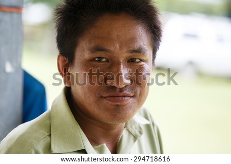 RHI, MYANMAR - JUNE 22 2015: Government Administration Official man wears smart green uniform in the recently opened region of Chin State in Western Myanmar (Burma)