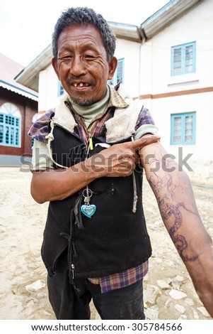 CHIN STATE, MYANMAR - JUNE 18, 2015: Tattooed man with homemade pen tattoo in the recently opened for tourists Chin State Mountainous Region, Myanmar (Burma)