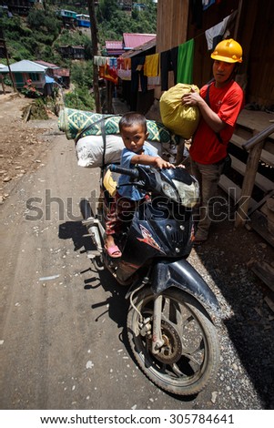 CHIN STATE, MYANMAR - JUNE 18, 2015: Young boy on motorbike in the recently opened for tourists Chin State Mountainous Region, Myanmar (Burma)