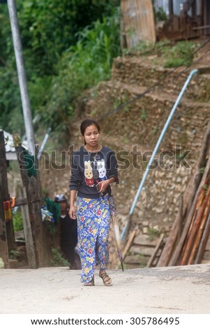 CHIN STATE, MYANMAR - JUNE 18, 2015: Lady walking through Falam Town in the recently opened for tourists Chin State Mountainous Region, Myanmar (Burma)