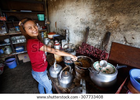 CHIN STATE, MYANMAR - JUNE 18 2015: Cute girl cooks traditional food in the recently opened for tourists Chin State Mountainous Region, Myanmar (Burma)