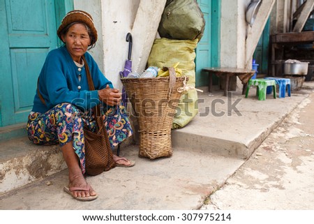 CHIN STATE, MYANMAR - JUNE 18 2015: Older lady sitting on street in the recently opened Chin State Mountainous Region, Myanmar (Burma)