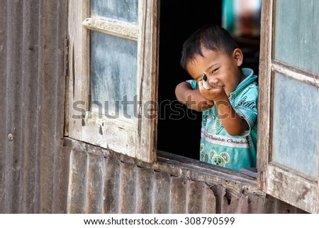 CHIN STATE, MYANMAR - JUNE 18 2015: Cute young boy in window in the recently opened for tourists Chin State Mountainous Region, Myanmar (Burma)