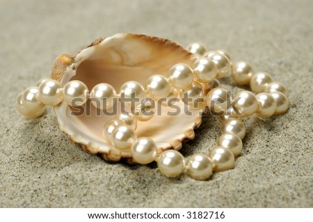 Sea shell with pearls on the sand