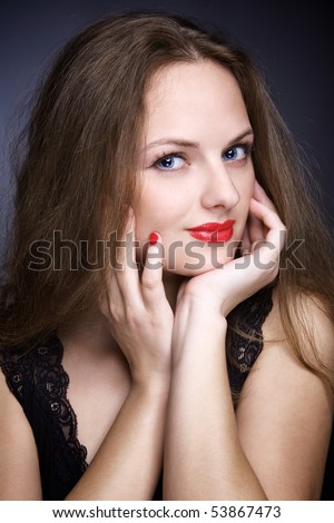 Portrait of beautiful young woman with big eyes, over dark. Studio shot