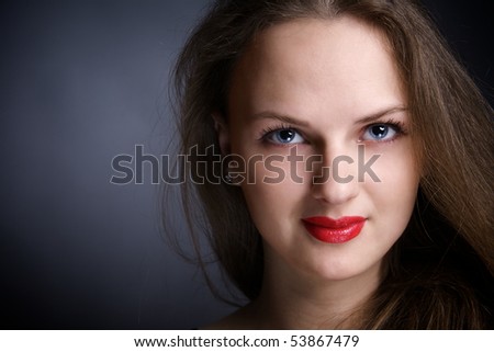Portrait of beautiful young woman with big eyes, over dark. Studio shot